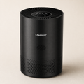 Black Room Reset H13 HEPA air purifier with its cylindrical replacement filter on a warm eggshell studio background