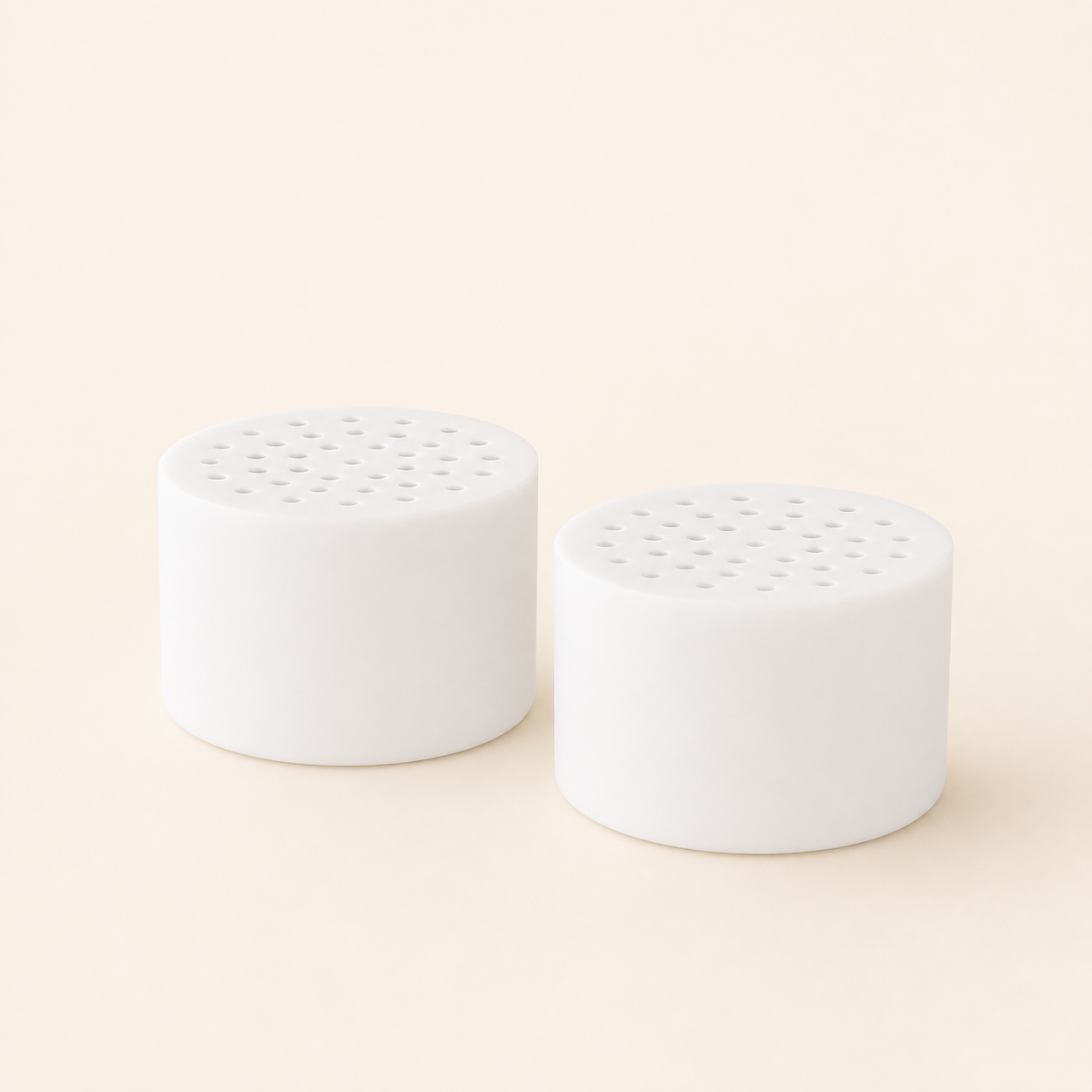 Two white CL-SF1 replacement shower filter cartridges on a warm eggshell background